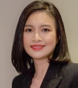 A person with dark hair wearing a black suit
Description automatically generated